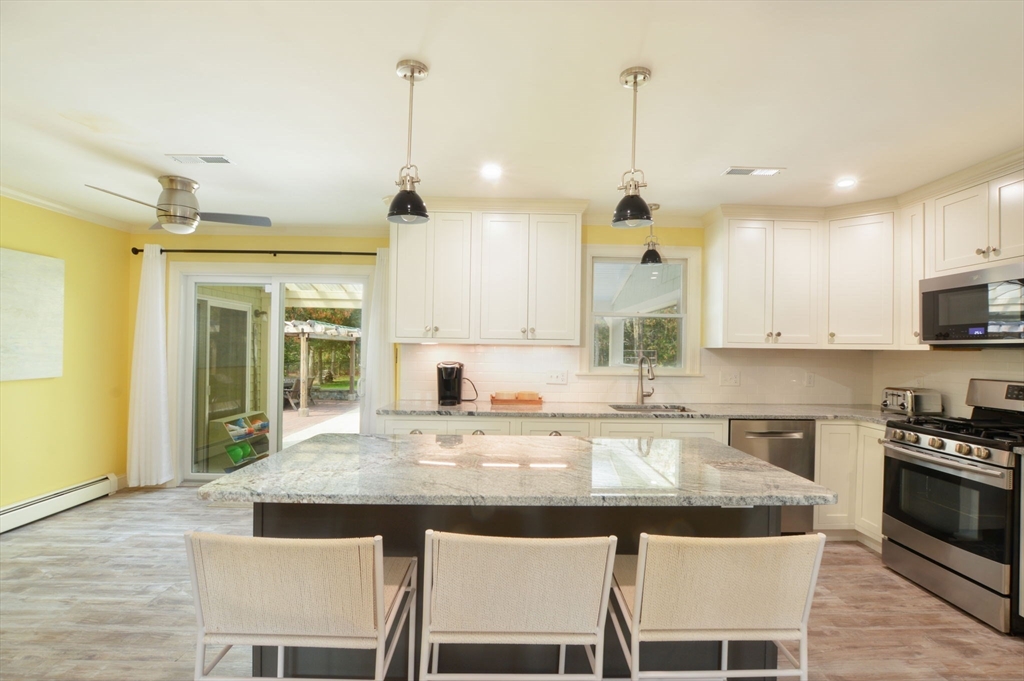 48 Tara Terrace Bourne, MA 02532 - Photo 18 of 33 a kitchen with kitchen island granite countertop a stove a sink a center island and cabinets