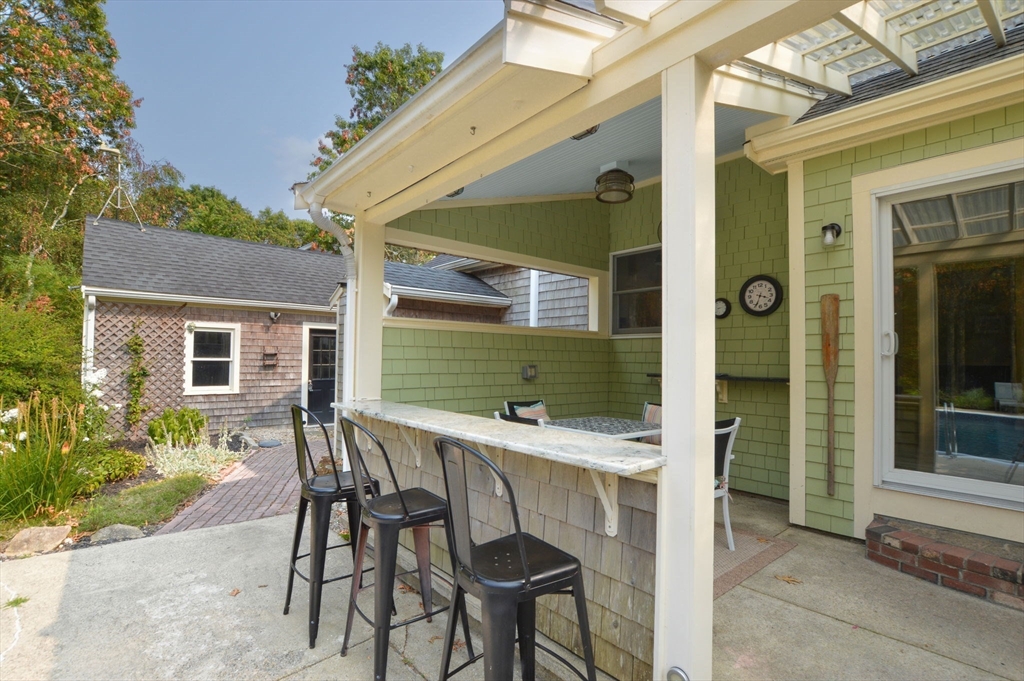 48 Tara Terrace Bourne, MA 02532 - Photo 4 of 33 a patio with table and chairs and potted plants