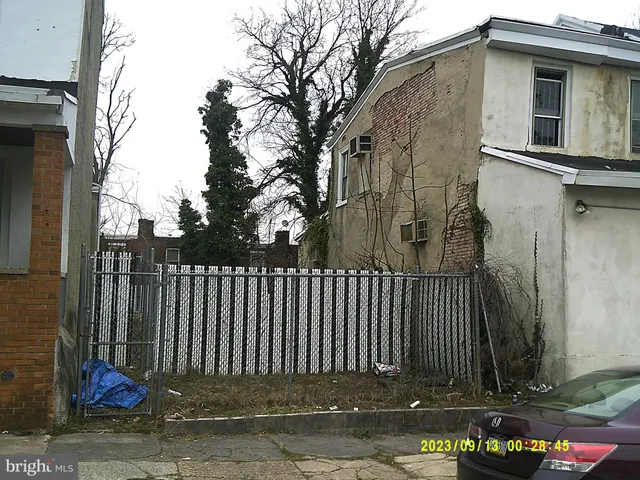 a view of a house with a small yard and wooden fence