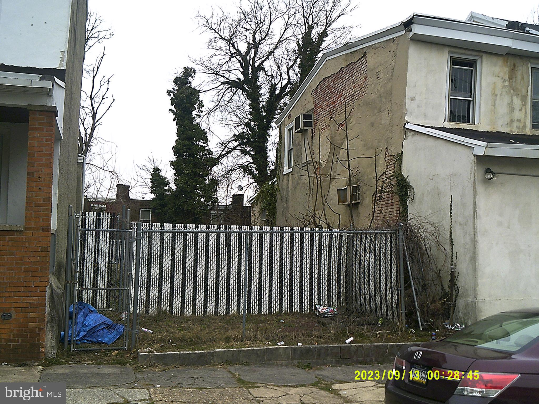 a view of a house with a small yard and wooden fence