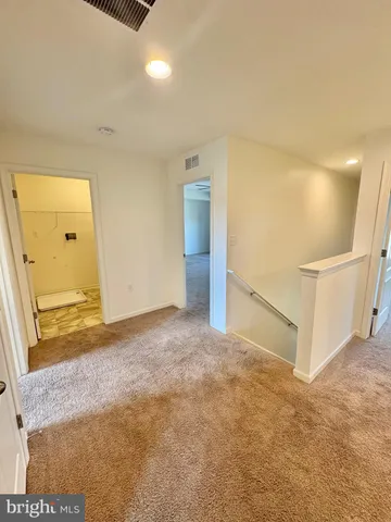 an empty room with windows and ceiling fan