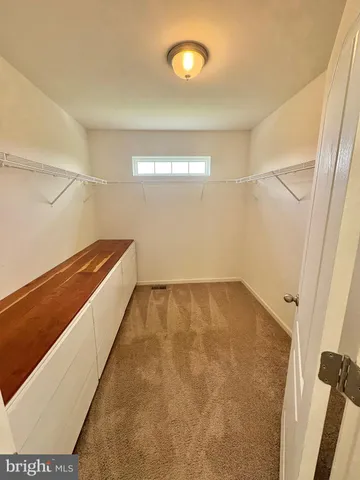 an empty room with a ceiling fan and window