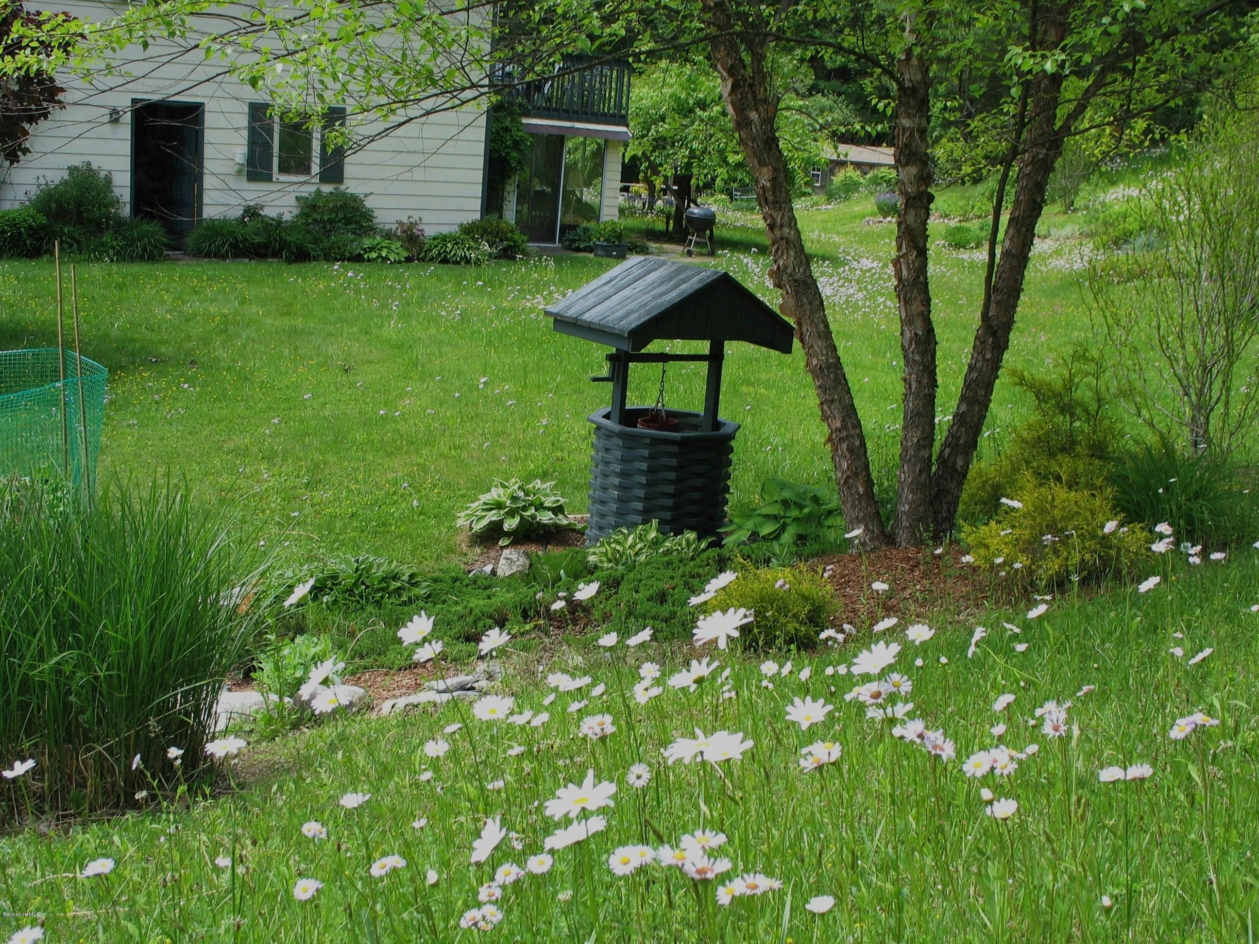 2131 Dublin Road Richmond, MA 01254 - Photo 41 of 51 a view of a garden with a bench under an umbrella