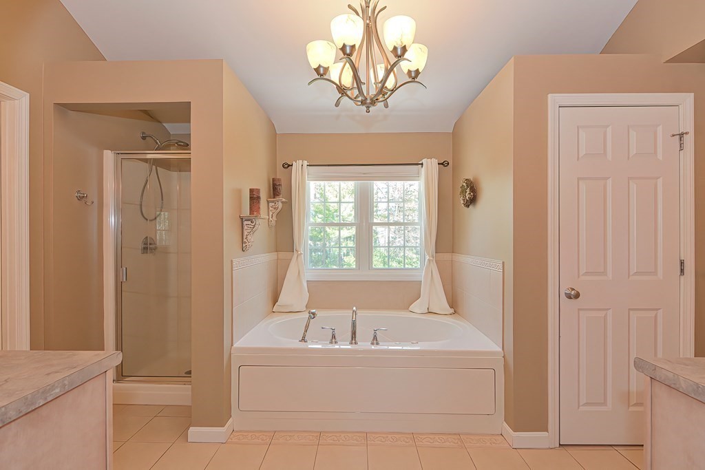 101 Paradise Lane Rochester, MA 02770 - Photo 22 of 42 a bathroom with a bathtub and a chandelier