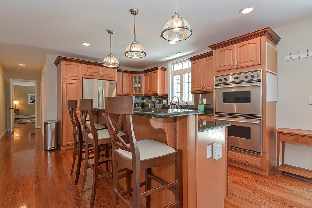 101 Paradise Lane Rochester, MA 02770 - Photo 3 of 42 a kitchen with stainless steel appliances granite countertop a stove top oven a refrigerator and chairs with wooden floor