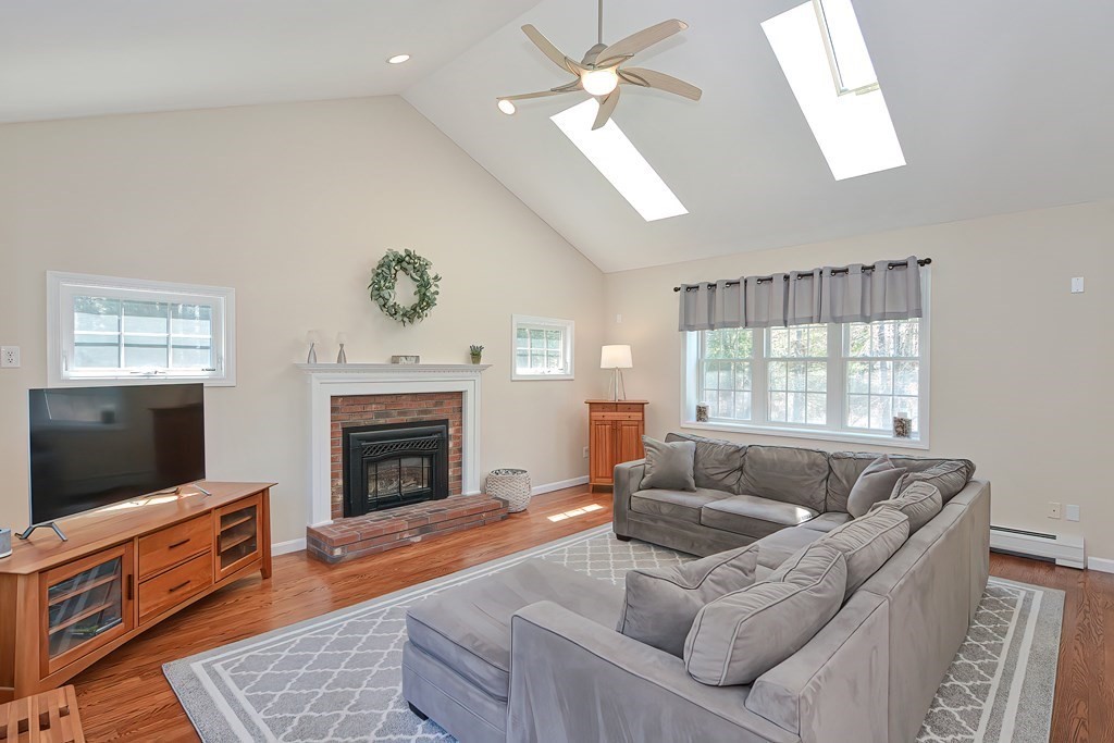 101 Paradise Lane Rochester, MA 02770 - Photo 7 of 42 a living room with furniture a flat screen tv and a fireplace