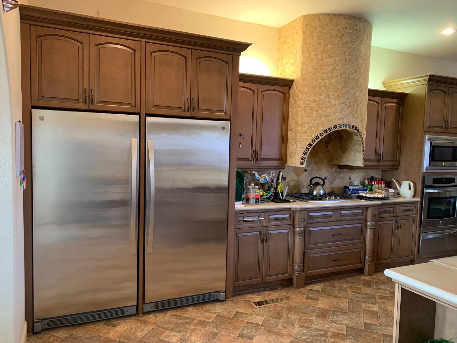 1662 South Alta Avenue Reedley, CA 93654 - Photo 20 of 30 a kitchen with stainless steel appliances granite countertop a refrigerator a stove and a sink