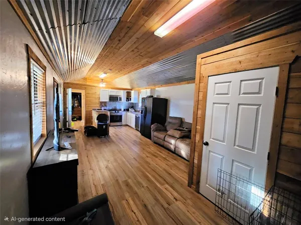 a living room with furniture a flat screen tv and a refrigerator