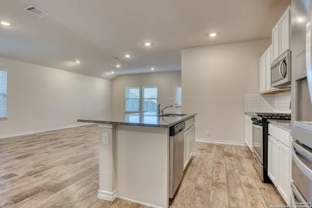 a kitchen with stainless steel appliances granite countertop a sink and stove top oven