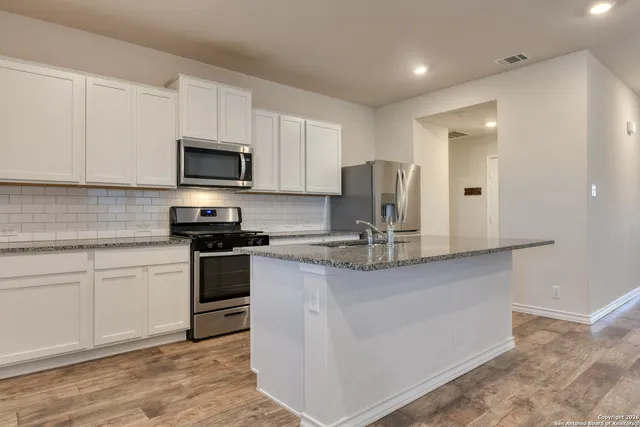 a kitchen with appliances a sink and cabinets