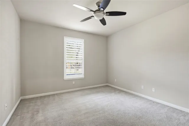 an empty room with wooden floor cabinet and windows