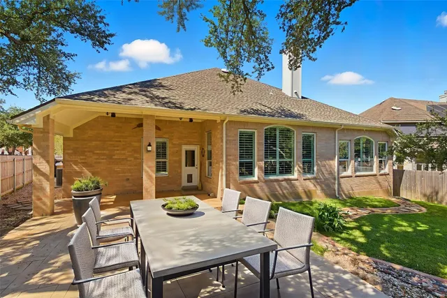 a view of a house with backyard and sitting area