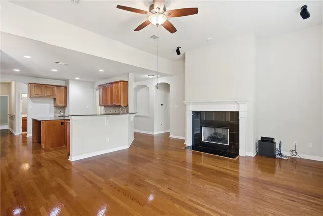 a view of empty room with wooden floor and a fireplace