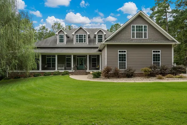 a front view of a house with swimming pool and garden