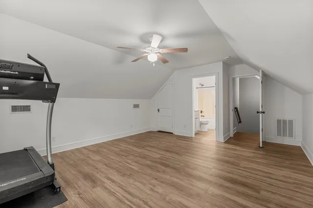 a view of empty room with wooden floor and ceiling fan