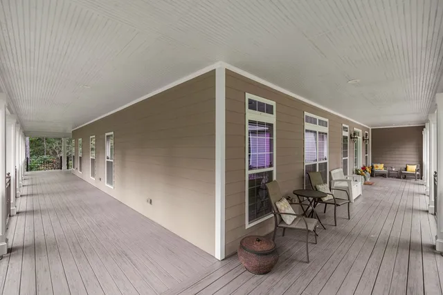 a view of a patio with table and chairs with wooden floor and fence