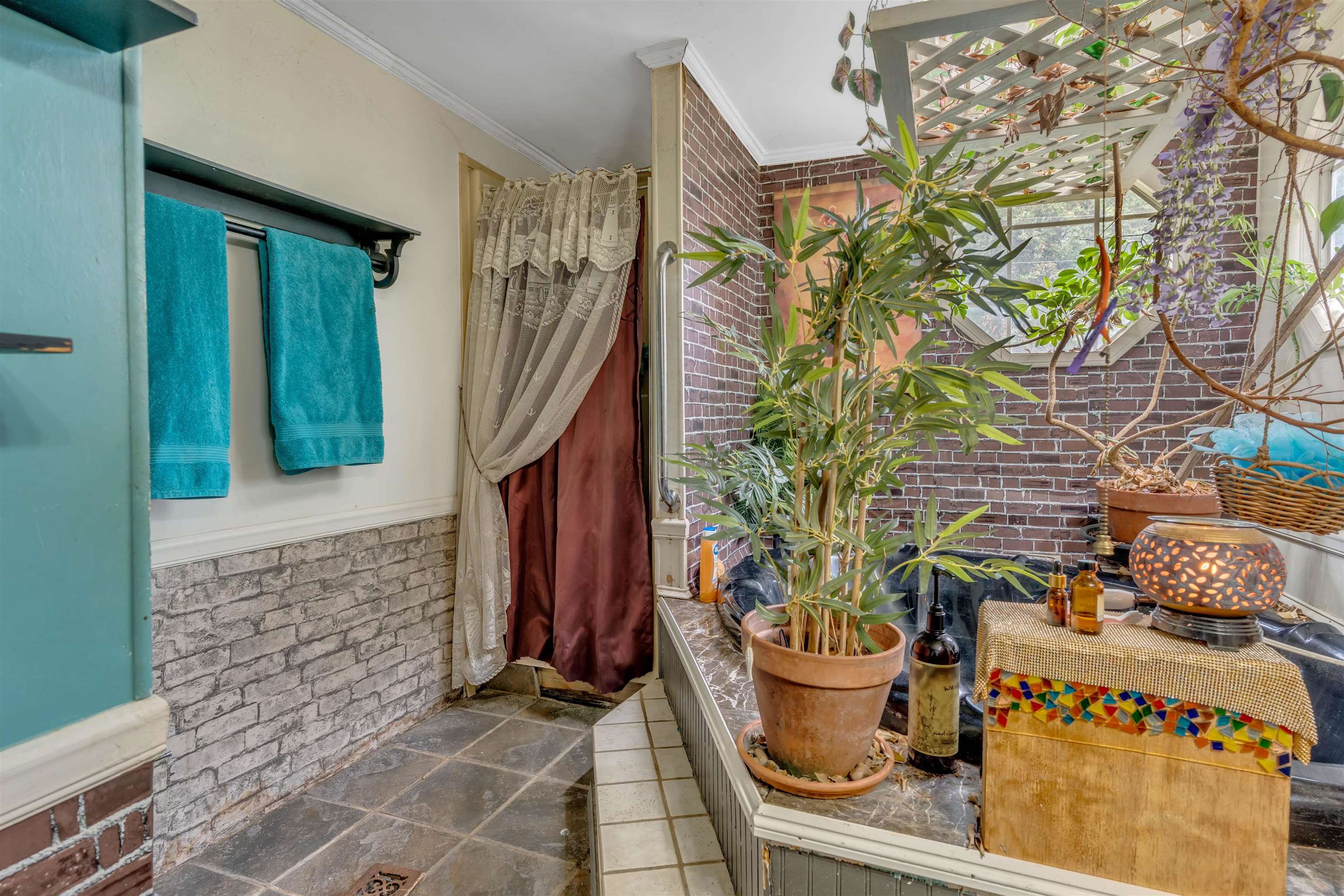 328 Cates Road Halls, TN 38040 - Photo 19 of 36 Brick accent wall with an integrated trellis, tiled shower floor, and a built-in tub with mosaic detailing