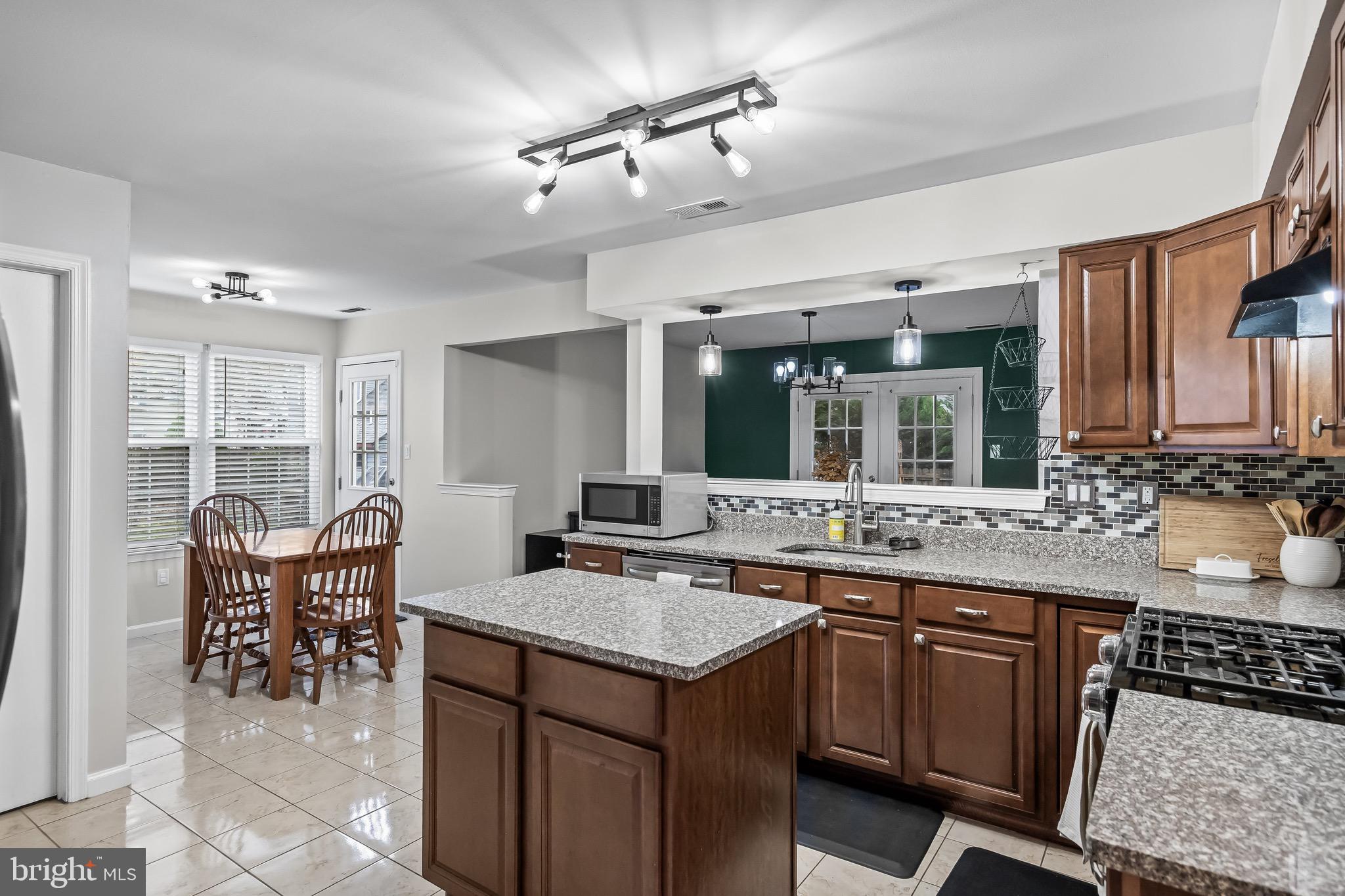 5 Hampton Court Mount Laurel, NJ 08054 - Photo 20 of 46 a kitchen with a stove a sink a dining table and chairs