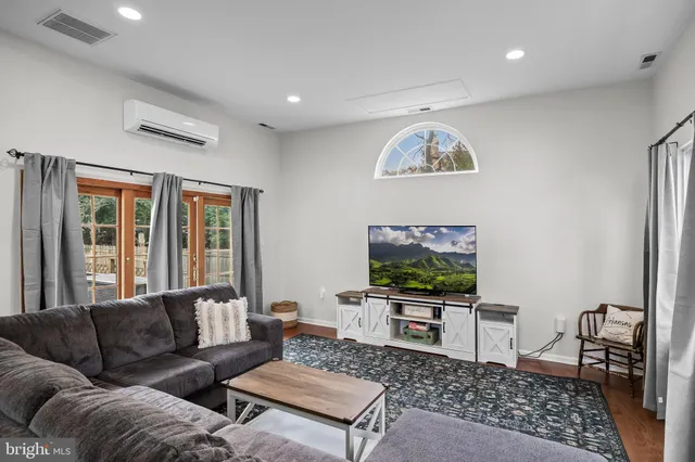a living room with furniture a large window and a flat screen tv