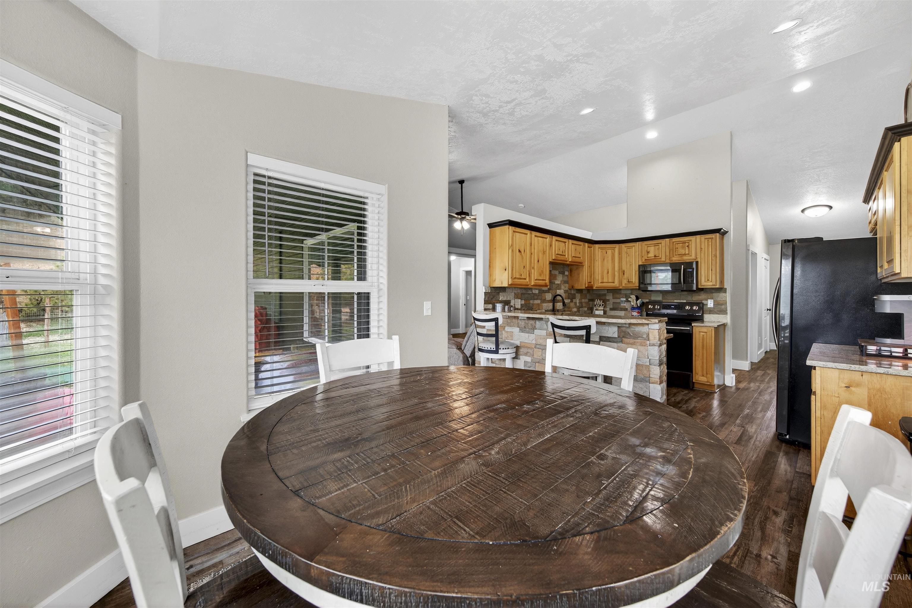 4 Round Up Circle Boise, ID 83716 - Photo 14 of 47 Dining area featuring two windows with white blinds, wood-finish flooring, and light-toned wall paint