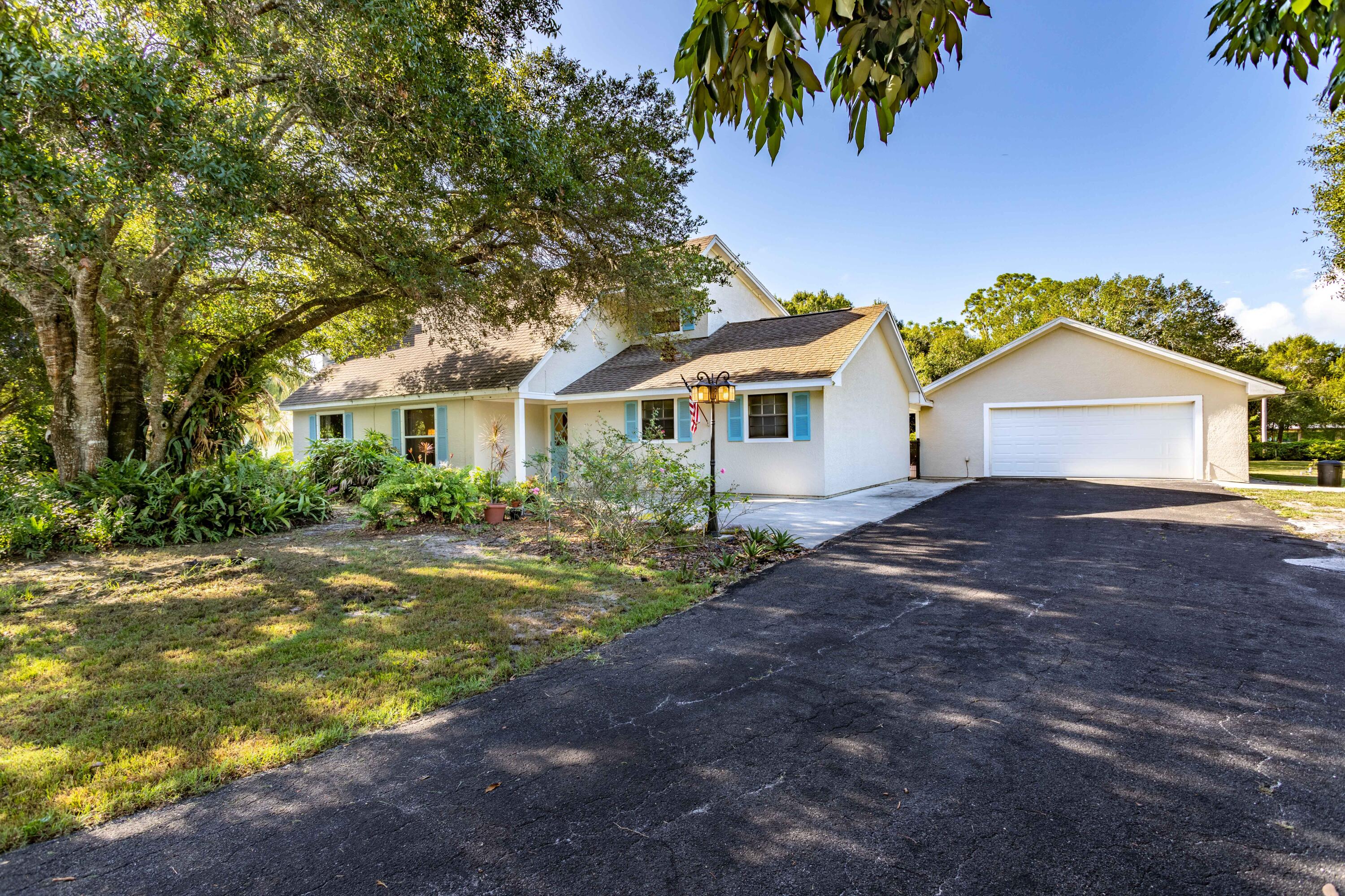 8791 Hidden Pines Road Fort Pierce, FL 34945 - Photo 1 of 55 a front view of a house with a garden