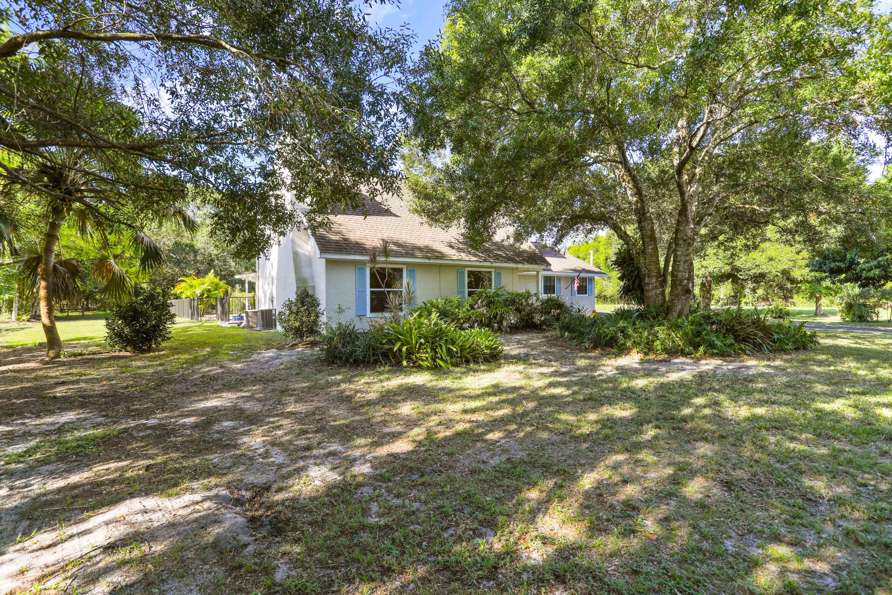 8791 Hidden Pines Road Fort Pierce, FL 34945 - Photo 4 of 55 a house with trees in front of it