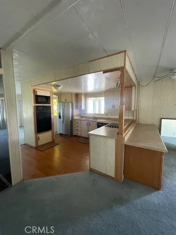 a kitchen with stainless steel appliances kitchen island granite countertop a refrigerator and a sink