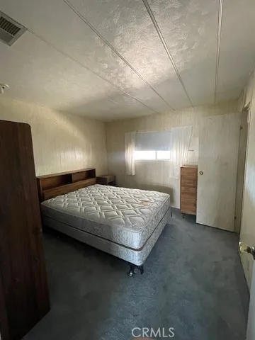 a large bedroom with a bed and a mirror