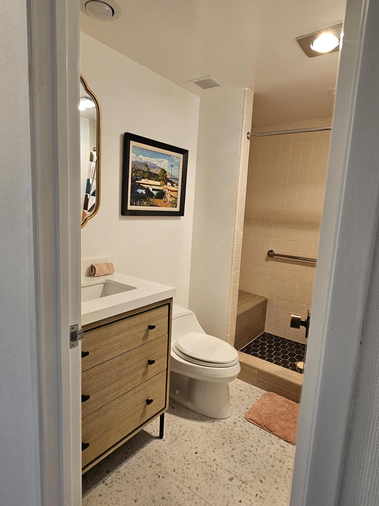910 Island Drive, Unit 113 Rancho Mirage, CA 92270 - Photo 26 of 40 a bathroom with a granite countertop toilet a sink and a mirror