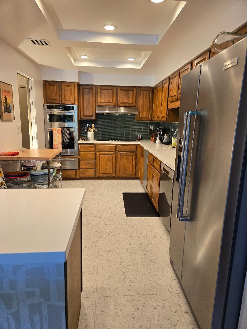 910 Island Drive, Unit 113 Rancho Mirage, CA 92270 - Photo 31 of 40 a kitchen with stainless steel appliances kitchen island granite countertop a refrigerator and a stove top oven