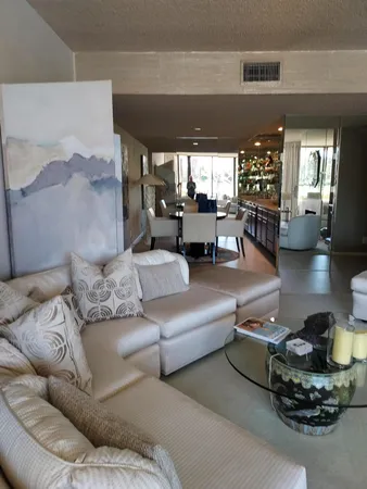 a view of a hallway to a livingroom and a livingroom with furniture