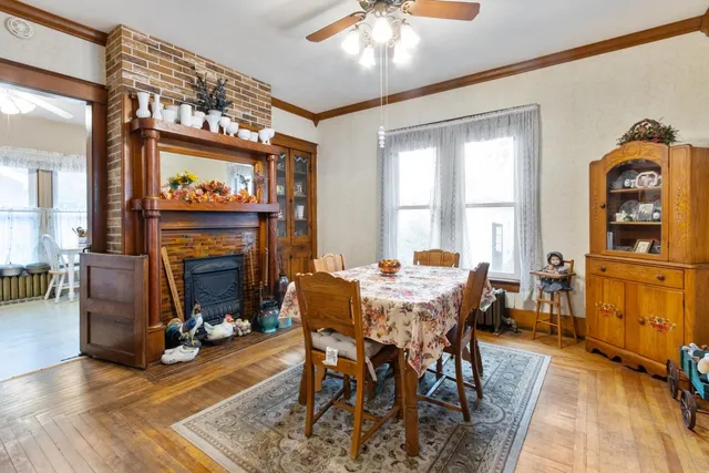 a dining room with furniture a fireplace and wooden floor
