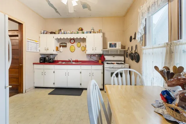 a view of kitchen with stainless steel appliances granite countertop a sink and cabinets