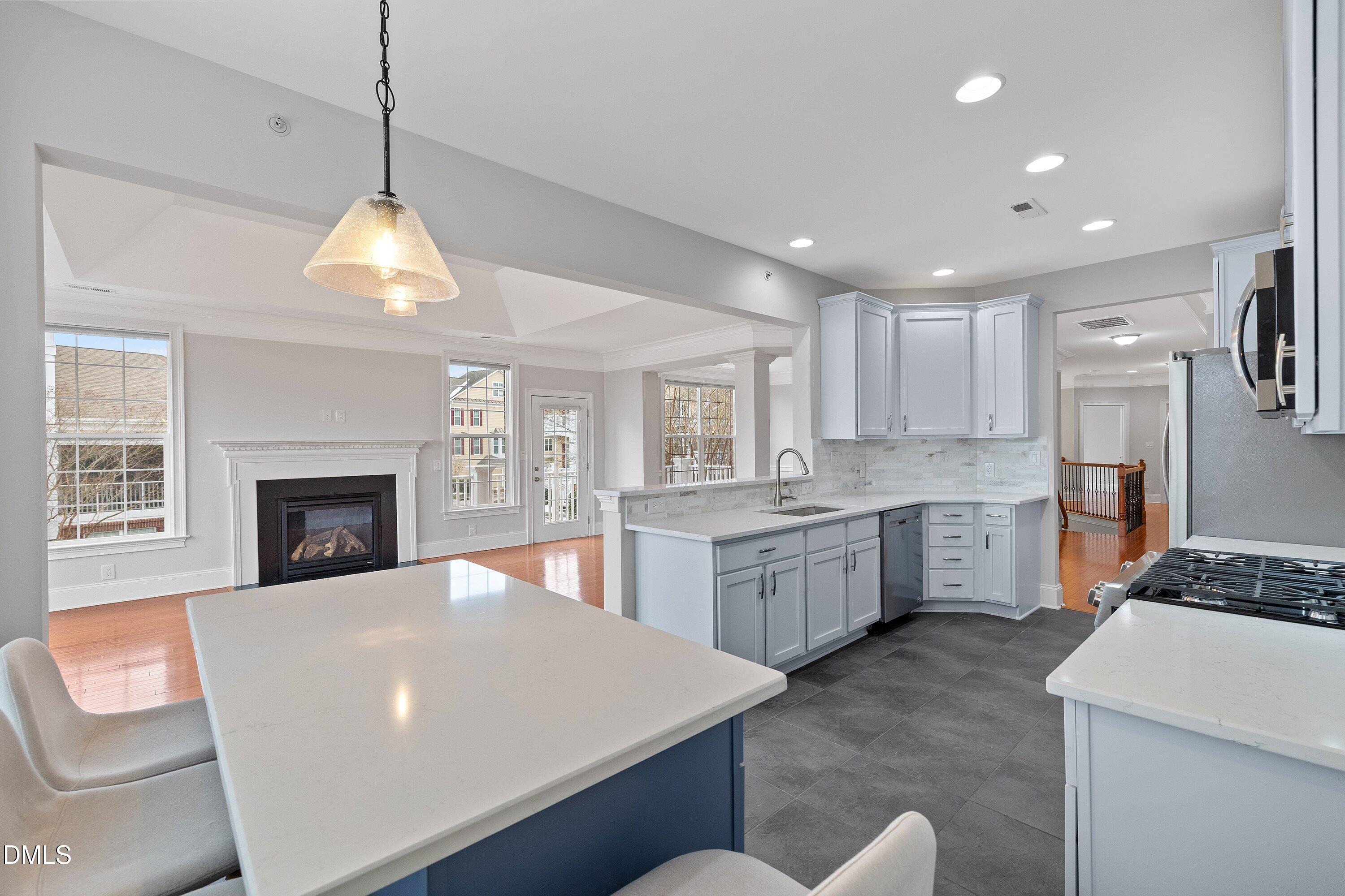 9211 Calabria Drive, Unit 205 Raleigh, NC 27617 - Photo 23 of 55 a large white kitchen with a stove a sink a refrigerator dining table and chairs