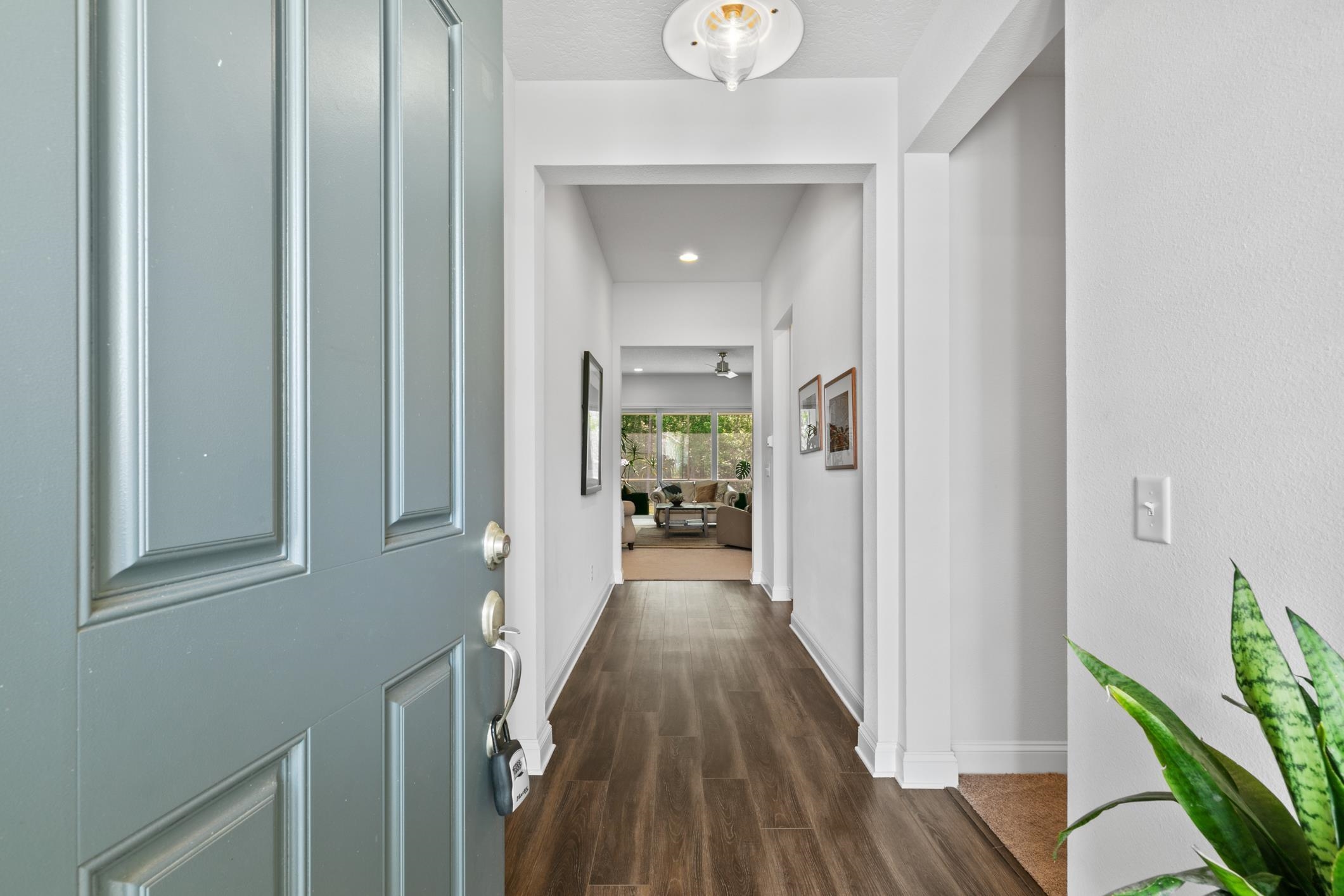 345 Downs Corner Road St. Augustine, FL 32092 - Photo 4 of 38 a view of a hallway with wooden floor and a livingroom