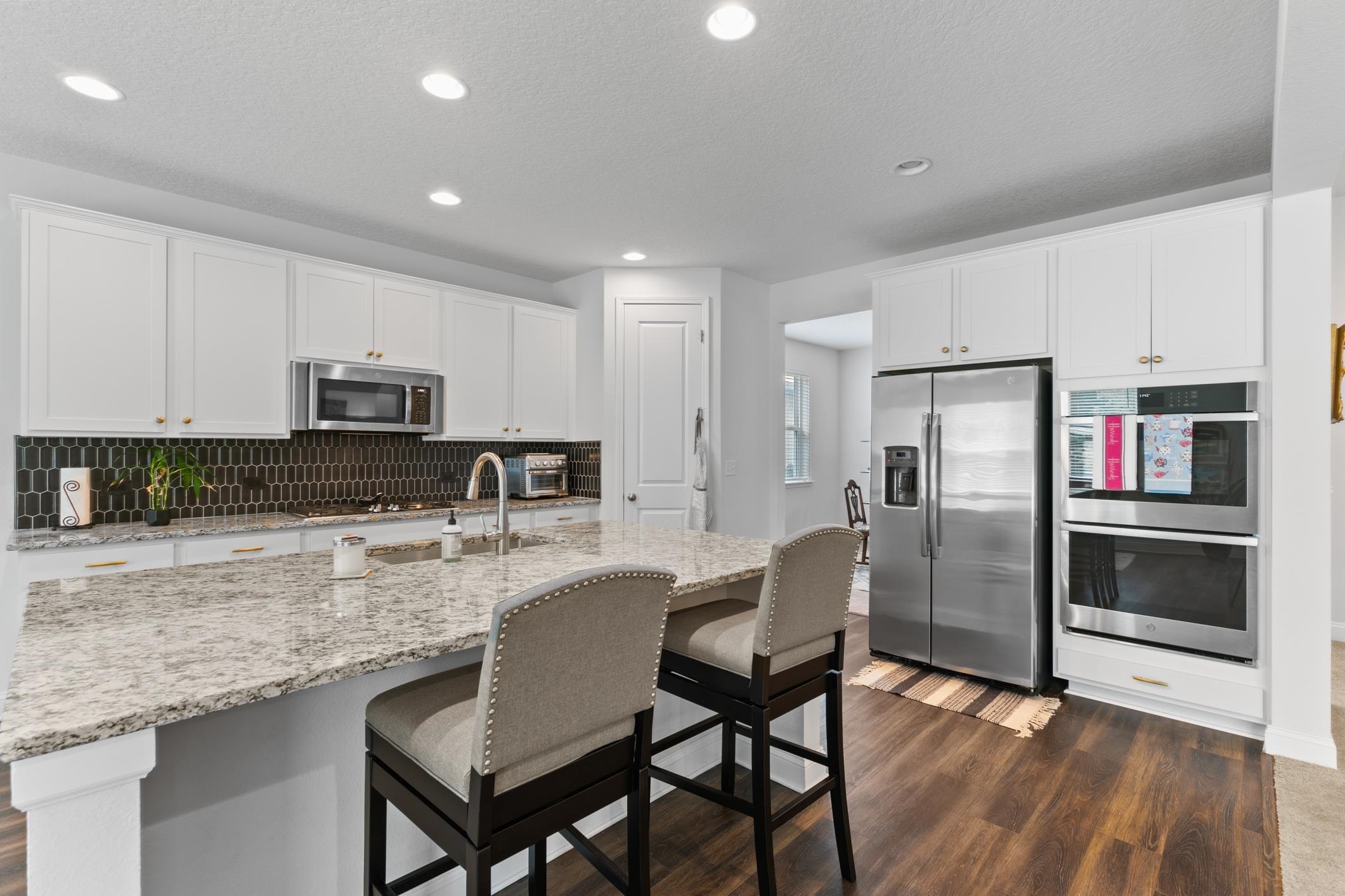 345 Downs Corner Road St. Augustine, FL 32092 - Photo 10 of 38 a kitchen with stainless steel appliances granite countertop a refrigerator a stove a sink a dining table and chairs