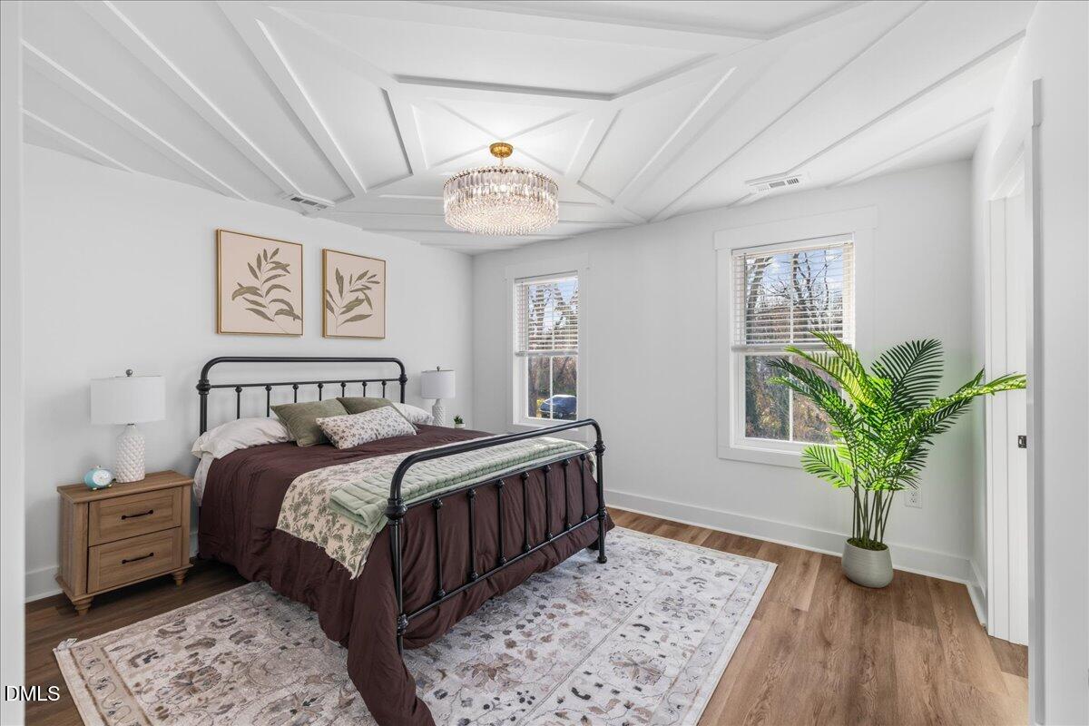617 North 3rd Street Mebane, NC 27302 - Photo 27 of 50 a bedroom with a large bed and a chandelier