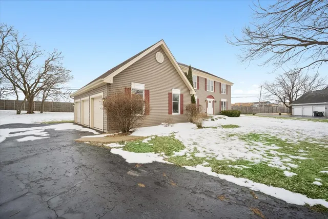 a front view of a house with a yard covered in snow