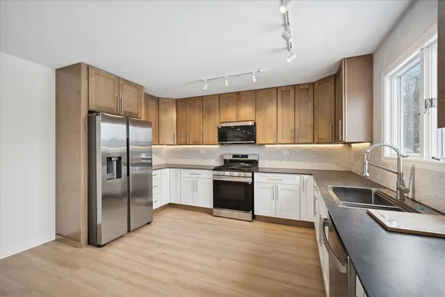 a kitchen with granite countertop stainless steel appliances cabinets a sink and a center island