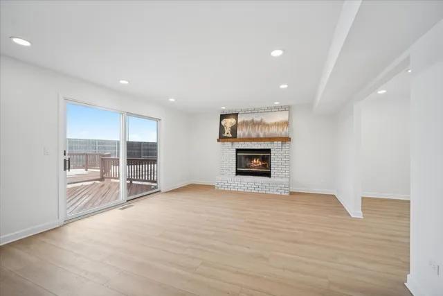an empty room with windows and fireplace
