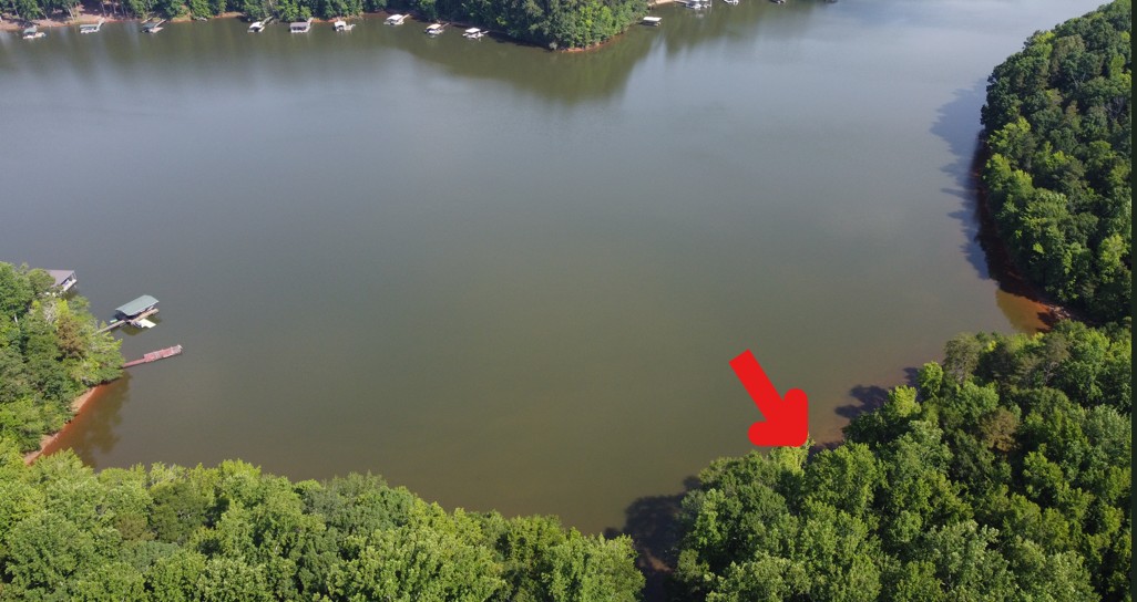 This elevated view captures a serene waterfront lot, offering a prime opportunity for waterside living.