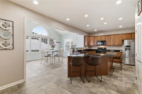 a living room with stainless steel appliances kitchen island granite countertop furniture and a view of kitchen