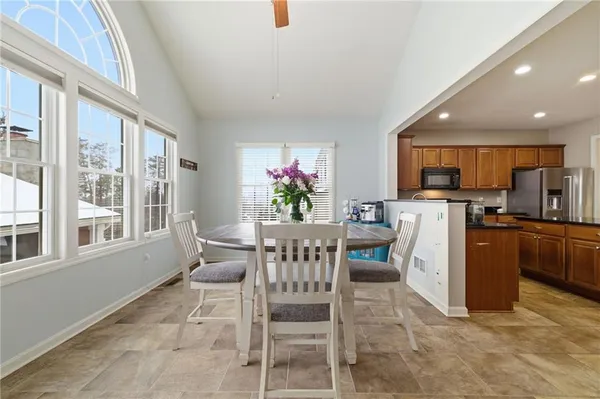 a view of a dining room with furniture a kitchen and chandelier