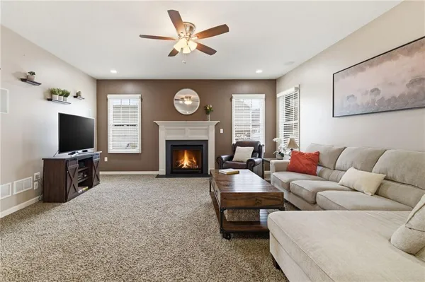 a living room with furniture a flat screen tv and a fireplace