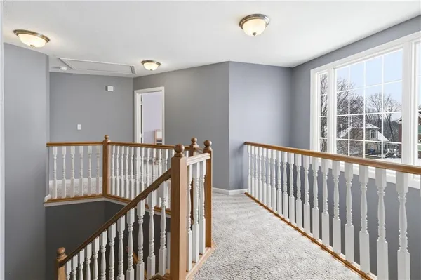 a view of a hallway with wooden floor and a window