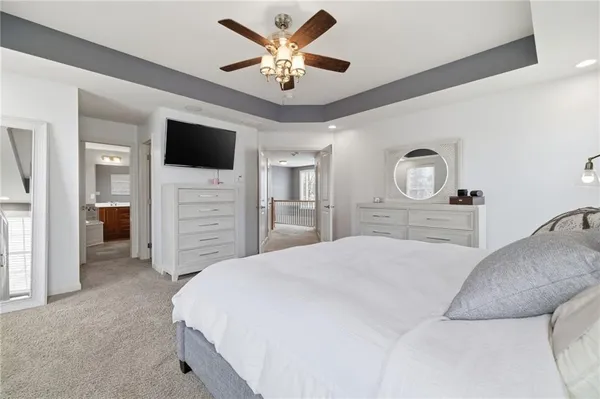 a spacious bedroom with a bed and a flat screen tv