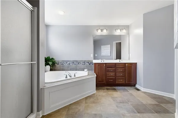 a bathroom with a tub a sink and a mirror