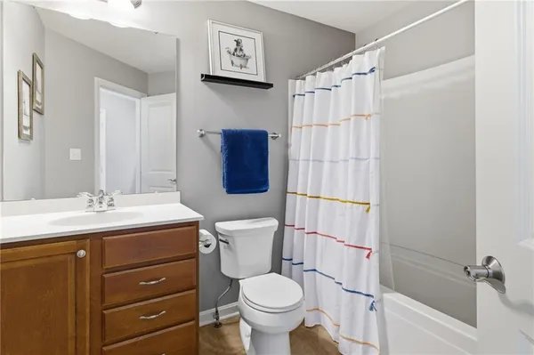 a bathroom with a granite countertop toilet sink and mirror