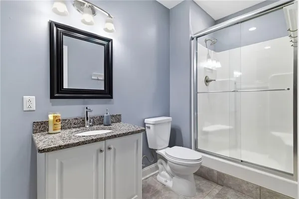 a bathroom with a granite countertop toilet sink and mirror