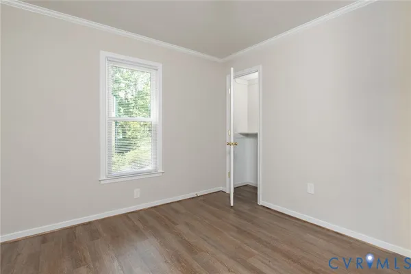 an empty room with wooden floor and window